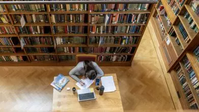 Student reading in the Howard Piper Library, St Hugh's College