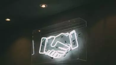 Neon sign of a handshake 