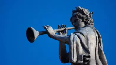 A statue blowing a trumpet