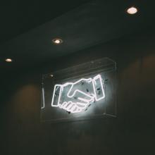 Neon sign of a handshake 
